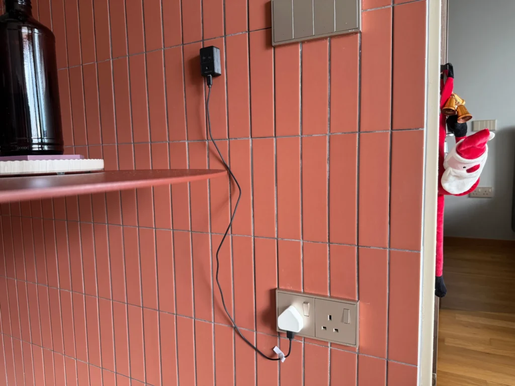 XIAO MR60BHA2 sensor mounted on a wall next to a Santa Claus doll